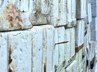 Close-up view of stacked styrofoam boxes, showing signs of use, wear, and tape reinforcement. The textured surface and alignment give an industrial, rugged feel.

