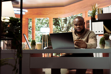 Successful freelancer does online shopping with his credit card, making electronic banking...