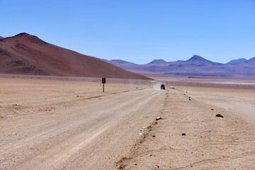 Bolivia, Salvador Dali Desert. Avoroa Nationa Park,  A road leading through the desert towards the mountains.