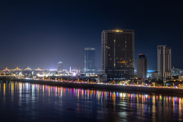 Fototapeta premium Tonle Sap river bank with modern buildings and residential areas district night panorama, Phnom Penh city panorama, Cambodia