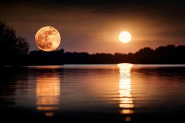 Majestic sunset and full moon reflection over serene lake at dusk highlighting the beauty of nature