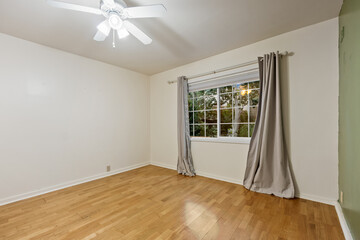 Spacious living room with wooden flooring and sliding doors leading to a bright outdoor area