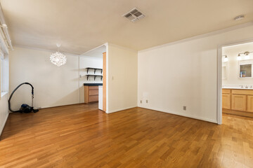 Spacious living room with wooden flooring and sliding doors leading to a bright outdoor area