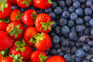 Top view of freshly picked strawberries and blueberries side by side, showcasing vibrant colors, natural sweetness and antioxidant-rich fruits. Healthy summer snacks and balanced nutrition