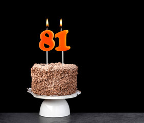 Birthday card with candle number 81 - Chocolate cake on black background.