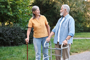 Senior couple with walking frame and cane in park