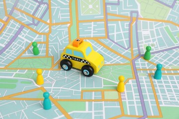 Yellow taxi car and colorful human figures on city map