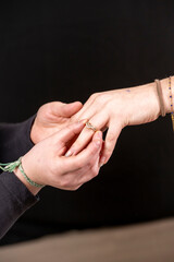 main glissant une bague au doigt de la main d'une autre personne, demande en mariage © Esta Webster