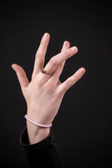 main d'une jeune femme croisant les doigts sur fond noir © Esta Webster