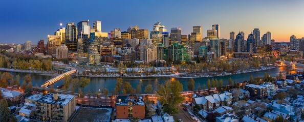 Calgary skyline at twilight, snow-covered city, illuminated buildings, and the Peace Bridge. Winter wonderland. Downtown, Calgary, Alberta, Canada