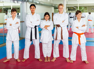 Portrait of teenager children with their female instructor posing at gym after group training