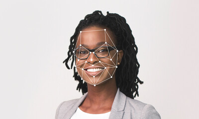 A smiling woman with glasses and dreadlocks is showcased against a light background, highlighting...