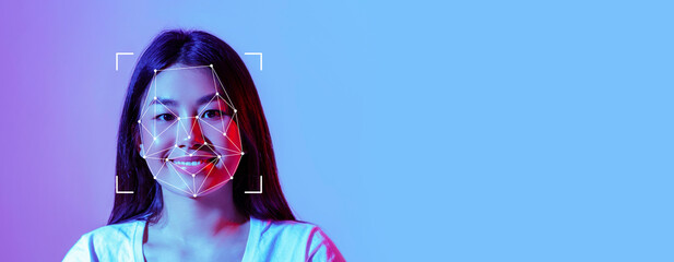 A person smiles as facial recognition technology is applied to their features. The background is...