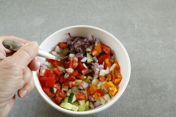 mixing diced vegetable salad in bowl