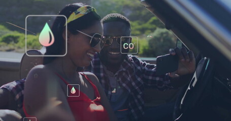 Laughing couple in convertible with environmental data image overlaid