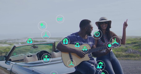 Playing guitar and dancing, couple in convertible over sustainability icons image