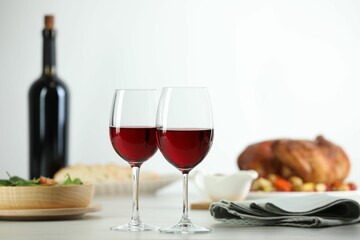 Red wine and delicious dinner served on light table