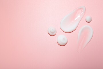Cream samples on pink background, top view. Skincare product