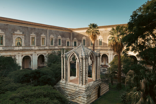 Chiostro dei Marmi with La Caffeaus, designed by architect Musumeci, graces the garden of Monastero dei Benedettini di San Nicol&ograve; l'Arena, Catania. A serene fusion of history, art, and nature.