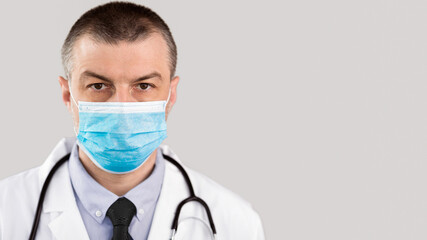 Profession and Medicine Concept. Close up of male doctor or scientist in protective facial mask over white background
