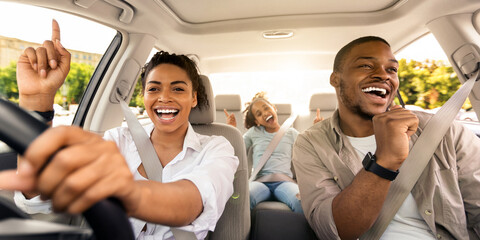 Cheerful Black Family Singing Riding New Car Having Fun Enjoying Road Trip On Vacation. Parents And...