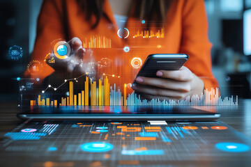 Hands using smartphone in front of laptop displaying digital data and analytics charts
