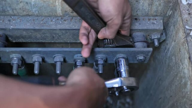 4K video of an electrician using a wrench to tighten bolts on a ground bar in a grounding pit for soil resistance testing. Perfect for technical training and safety videos