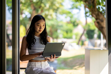 A woman is sitting outside and using a laptop