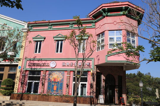 A pink and green three-story building with art deco style, decorated in the shape of Doraemon's house