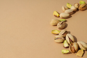 Pistachios in a plate, on a beige background.
