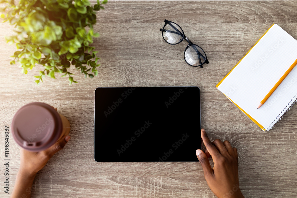 Poster top view of black woman with coffee using tablet computer for online shopping on wooden table, close
