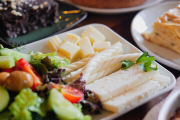 An exquisite and delicious platter featuring fresh salad and gourmet cheese