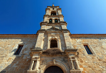 Fototapeta premium A stunning view of a historic church tower, crafted from stone, showcasing intricate architectural details against a vivid blue sky.