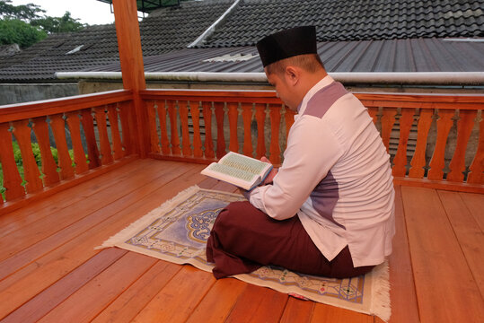 Asian Muslim man reading Quran
