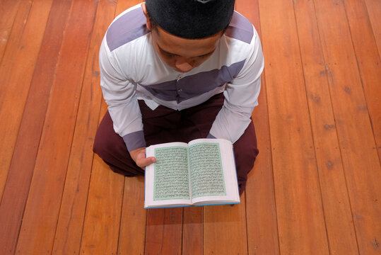 top view of Muslim man reading Quran