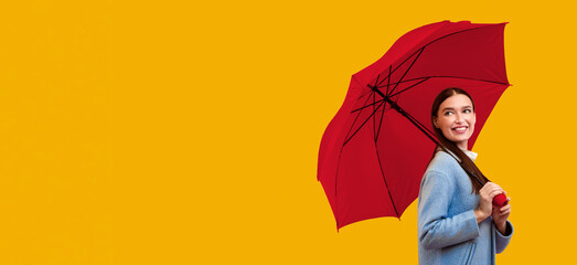 Fancy Girl. Portrait of fashionable girl carrying yellow parasol and looking back at copy space for you ad, logo or text © Prostock-studio