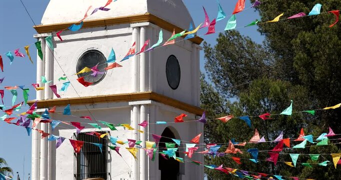 Colorful papel picado frames the historic clock tower of the downtown train station in Heroica Nogales, Sonora, Mexico.
