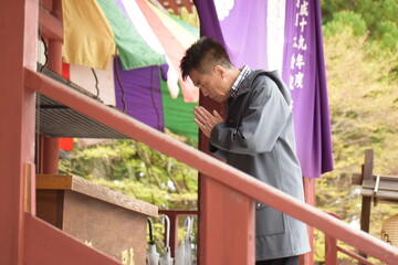 お寺でお参りをするシニア男性