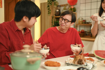 Warm asian family enjoying traditional dishes during Chinese New Year reunion dinner