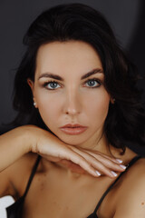 Fototapeta premium Portrait caucasian woman in green dress posing on white background touching face. Front view. Looking at camera.