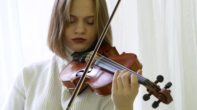 Woman fiddler playing violin quickly with bow, focused on performance. Female practicing acoustics skills, musical expression, speed and precision on concert, instrument mastery, music rehearsal