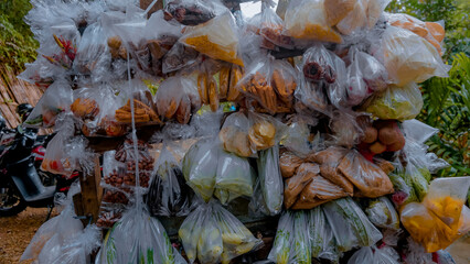 A variety of local vegetables are displayed in plastic bags on the vehicle