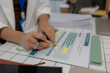 there are a lot if documents pied up on the desk if the data analysis team leader, an employee sits...