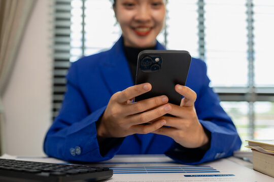 businesswoman sitting by the window with mobile phone at startup office, connection and woman typing on a phone for communication, female entrepreneur with smart phone and laptop working in office