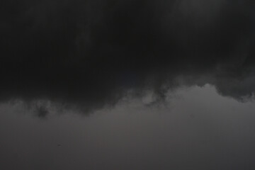 The dark sky with heavy clouds converging and a violent storm before the rain.Bad or moody weather sky and environment. carbon dioxide emissions, greenhouse effect, global warming, climate change.