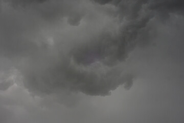 The dark sky with heavy clouds converging and a violent storm before the rain.Bad or moody weather sky and environment. carbon dioxide emissions, greenhouse effect, global warming, climate change.