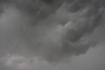 The dark sky with heavy clouds converging and a violent storm before the rain.Bad or moody weather sky and environment. carbon dioxide emissions, greenhouse effect, global warming, climate change.