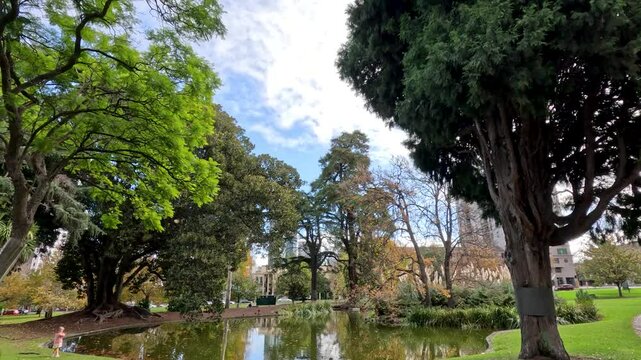 Child Playing by Duck Pond in Park