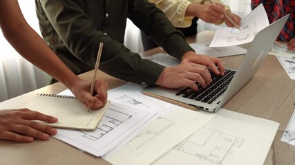 Architect and engineer consulting construction detail blueprint display in laptop on table with architectural document or plan and measurement tool for accuracy at modern office. Closeup. Delineation.