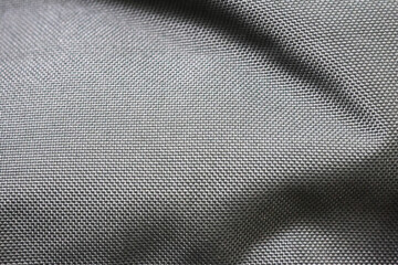 A close-up of a smooth, gray fabric with a tightly woven pattern. The material has a glossy finish and is likely used for outdoor gear such as jackets or backpacks due to its durability